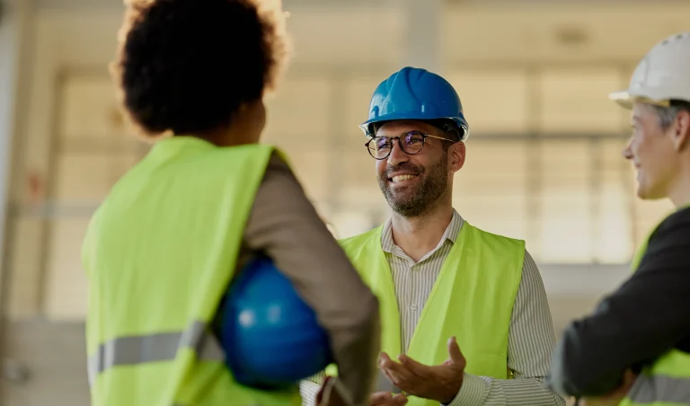 two female construction workers and a man on a construction site