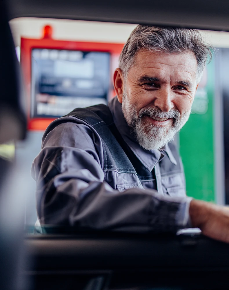 blue collar middle aged man looks into a car